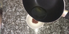 Đun sôi dầu ăn và cho vào chén hạt điều màu để làm nước màu điều.