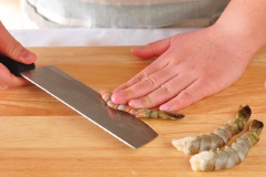 Tôm sú bóc vỏ, bỏ đầu, giữ lại đuôi cho đẹp mắt. Rạch lưng tôm, rút chỉ đen. Tôm đem rửa sạch lại rồi dùng giấy thấm khô cho bớt nhớt, mình tôm khô cũng dễ làm hơn. Đặt tôm lên mặt thớt, dùng lưỡi dao khía lưng tôm, tách thân tôm làm đôi chứ không đứt hẳn, con tôm chỉ còn được gắn với nhau ở phần bụng tôm