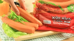 Cắt lát xéo 500gr xúc xích vừa ăn và khứa gân sao cho đẹp mắt.
