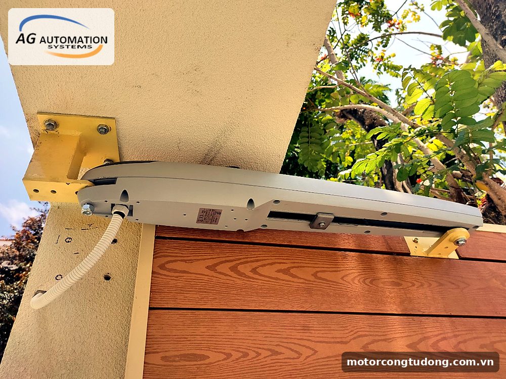 Motor tay đòn bắt sát dầm bê tông bằng bát thép, cánh cổng ốp gỗ – kiểu lắp hay gặp ở nhà phố Gò Vấp