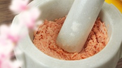 300gr cá hồi bỏ phần da, đem rửa sạch với nước muối loãng để khử mùi tanh, sau đó vớt cá ra để ráo nước. Cho cá vào xửng hấp chung với 10gr gừng thái sợi và 10gr đầu hành lá cắt nhỏ 10 phút. Khi cá chín bẻ ra thành những miếng nhỏ rồi cho vào cối, dùng chày giã cá thật nhuyễn.