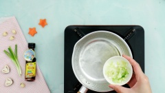 Cho chảo dầu nóng phi thơm 5gr đầu hành lá băm nhuyễn, cho tiếp thịt hàu đã cắt nhỏ vào xào cùng 1 muỗng cà phê nước nắm Hải Nhi. Xào đều tay trong 3 phút.