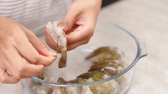 Tôm thẻ sống bóc bỏ vỏ, chỉ giữ lại một đốt cuối gần đuôi cho đẹp, lấy chỉ tôm sau đó rửa sạch.