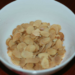Hạt nhân cắt lát cho vào chảo, rang lửa nhỏ cho vàng.