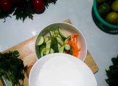 Cắt nhỏ ngò rí dài khoảng 2cm, trộn cùng cà rốt và dưa leo. Từ từ rưới nước dầu và chanh vào, đảo đều giúp dưa leo và cà rốt được dầu chanh bao bọc trọn vẹn.