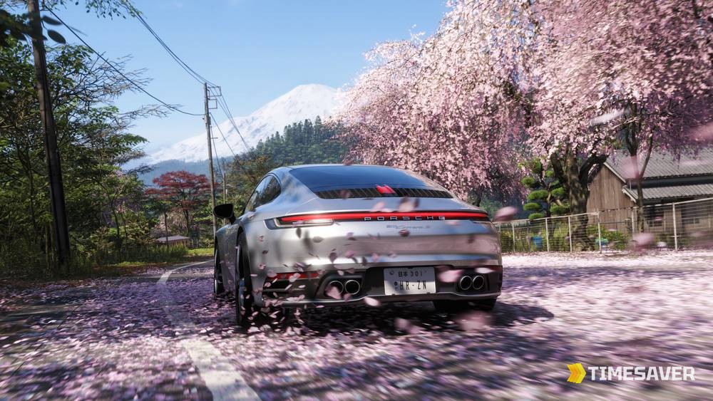 Porsche 911 driving a cherry-blossom mountain road in Forza Horizon 6 — free-roam exploration is what feeds your Discover Japan stamps