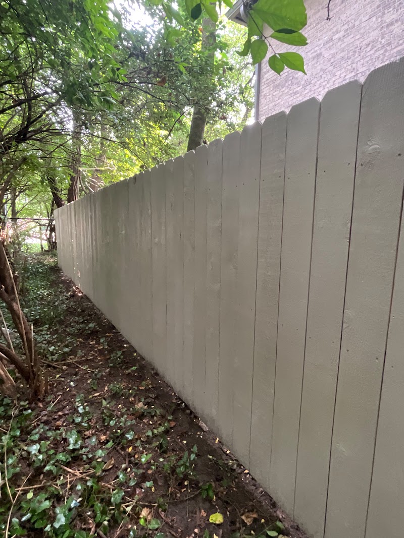 Stained condo-facing side of the Roundtree border fence running along a shaded bed