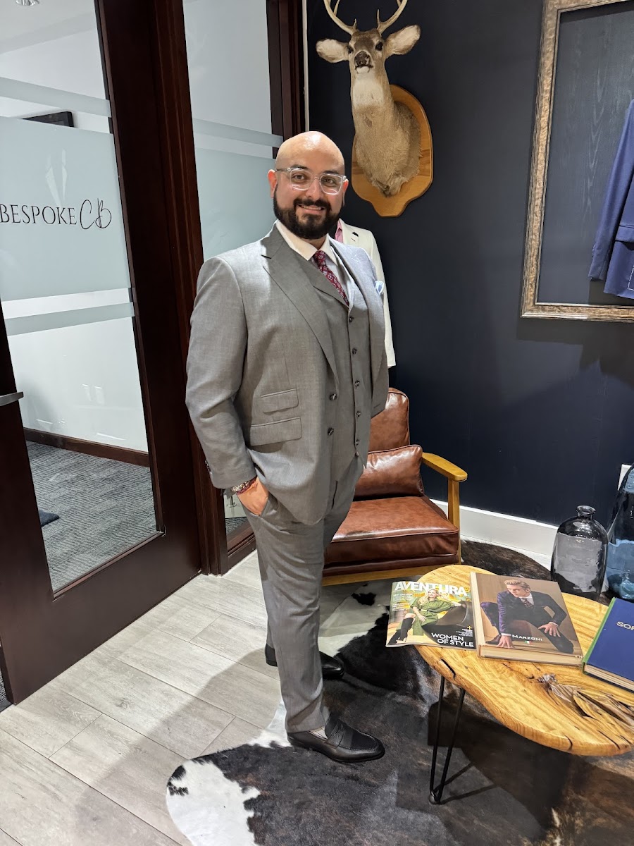 Man wearing a black velvet bespoke dinner jacket with open-collar shirt at a cocktail lounge — styled by Bespoke By CB Miami