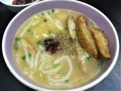 Múc bánh canh canh chả cá Quy Nhơn ra tô, thêm tiêu xay, chả cá chiên và ít sa tế ớt nếu thích ăn cay nhé. Chuẩn bị thêm một chén tương ớt để chấm chả cá sẽ giúp hương vị thêm đậm đà hơn.
