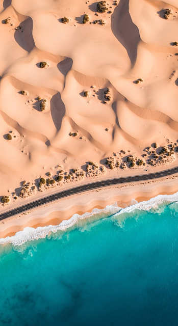 Overhead Aerial View of Desert Dunes, Coastal Road, and Turquoise Ocean Shoreline - Free mobile Wallpaper