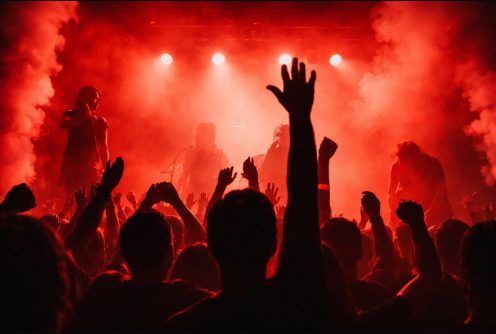 Foule dans une lumière rouge, une main levée