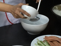 Pha hỗn hợp giấm đường trộn cơm cuộn rong biển: Cho 1 muôi canh giấm và 2 muôi canh đường, một ít muối vào một cái tô khuấy cho đường tan hết. Tiếp đến, múc 4 chén cơm ra thố sạch, dàn đều cơm cho cơm tơi, đổ hỗn hợp mới pha xong vào cơm, tiếp theo cho mè đã rang chín vào cùng, trộn đều.