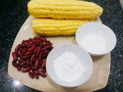 Bắp rửa sạch cả 2 bắp, loại bỏ râu ngô, để ráo. Sau đó, bạn thái dọc bắp để hạt rời khỏi lõi. Đậu đỏ ngâm vào nước cho mềm khoảng 3-4 tiếng, sau đó rửa sạch, cho vào nồi cùng 1 lượng nước bằng 3 đốt ngón tay, ninh mềm.
