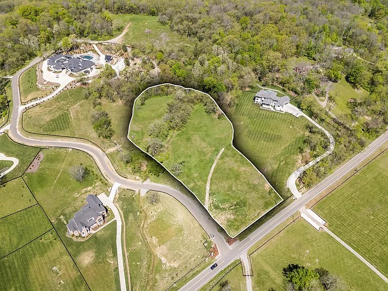 Aerial view of a residential development area with a white outline highlighting a specific grassy lot for the Brookland project.