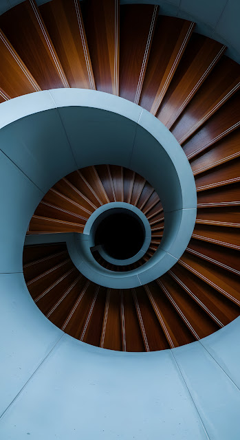 Abstract Top-Down View of a Modern Architectural Spiral Staircase with Wood Treads and Concrete Railing - Free mobile Wallpaper