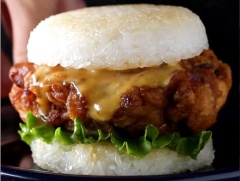 Đặt bánh burger cơm dưới cùng, sau đó là gà, sốt mù tạt mayonaise, xà lách, cà chua tùy ý, đặt miếng burger cơm còn lại lên trên và thưởng thức ngay thôi.