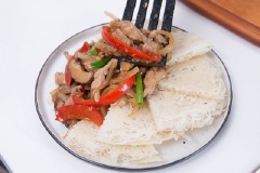 Thêm nước dùng gà, dầu hào, xì dầu, đường và hạt tiêu vào, đảo đều. Nấu cho đến khi nước xốt hơi sánh đặc lại, thêm hành lá thái nhỏ vào, đảo lại giây lát rồi tắt bếp. Trút thịt ra đĩa mì. Dùng nóng.