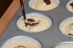 Đặt cốc giấy vào từng khuôn cupcake, múc hỗn hợp bánh vào cốc giấy. Rưới đều chocolate đen tan chảy lên bánh, cho vào lò, nướng khoảng 25 phút ở nhiệt độ 180 độ C.