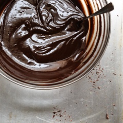 Băm nhỏ chocolate. Cho nước cốt dừa, dầu dừa, siro đường vào một cái tô rồi trộn đều. Đun nóng tô hỗn hợp trong lò vi sóng khoảng 30 giây cho đến khi hỗn hợp nổi bong bóng. Nhanh tay cho chocolate vào, trộn đều, nếu chocolate chưa tan chảy, bạn quay thêm 10 giây nữa nhé.