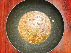 Đun nóng 1 muỗng canh nước mỡ heo, cho tỏi băm, sả băm, ớt băm vào cùng và xào cho dậy mùi thơm sau đó mới đổ tô nước sốt me vào cùng, khuấy đều và đun sôi hỗn hợp. Cuối cùng, cho tóp mỡ vào cùng và đảo đều cho tóp mỡ ngấm đều gia vị, rim khoảng 1-2 phút thì cho hành lá lên trên là tắt bếp.