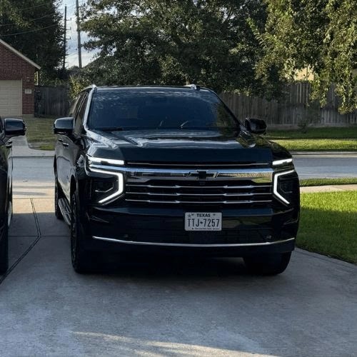 Front view of a black Chevrolet Suburban parked in a residential driveway