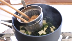 Sau đó, dùng rây cho vào nồi và múc 1 muỗng tương miso vào khuấy tan đều. Nấu canh cho sôi lại lần nữa là có thể tắt bếp được rồi nha. Múc canh miso ra chén, rắc hành lá lên trên và thưởng thức ngay khi còn nóng.