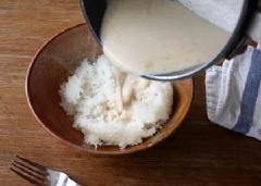 Cho xôi ra tô, chan đều nước cốt dừa lên trên, trộn đều.