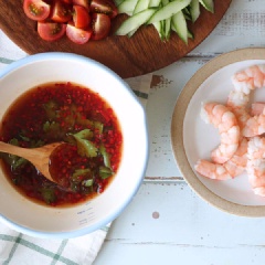 Ớt bỏ hạt, bằm nhỏ. Rau mùi thái nhỏ. Chuẩn bị một bát con, cho tất cả các nguyên liệu gồm: 4 muỗng canh nước mắm; 2 muỗng canh đường; 2 muỗng canh tỏi băm; ½ muỗng canh nước cốt chanh; 3 muỗng canh ớt đỏ cắt nhỏ vào trộn đều.