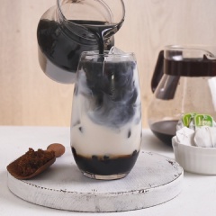 Pha trà sữa than tre: Cho trân châu đường đen vào dưới đáy ly, kế đến cho đá viên vào, rót sữa tươi vào gần đầy ly sau đó rót phần trà than tre lên trên cùng. Xem lớp màu chuyển đổi từ từ đẹp mắt chưa kìa, vậy là hoàn thành món trà sữa than tre độc đáo rồi.