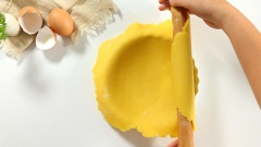 Chuẩn bị khuôn tart đế 16, viền 20cm, với khuôn này bạn sẽ làm được 2 chiếc quiche lorraine. Lấy bột ra khỏi tủ lạnh và cán mỏng khoảng 0,5 cm. Đặt miếng bột lên khuôn tart rồi cố định bột theo tạo hình khuôn, cắt bỏ những phần bột dư để sang một bên. Nếu nhà bạn có 2 khuôn tart thì có thể làm luôn cả 2 khuôn, nếu không thì cất khối bột còn dư vào tủ lạnh đến khi dùng tiếp. Đem cho khuôn bột vào tủ lạnh 15 phút.