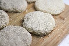 Sau khi bột làm bánh tiêu đã nở phồng, bạn dùng tay ấn nhẹ đều khắp khối bột bánh để bọt khí thoát ra hết. Vắt bột làm bánh tiêu thành hình trụ, chia bột bánh thành các phần nhỏ, vo tròn rồi lăn bột bánh qua mè trắng đã rang sẵn. Ấn hơi dẹp và để các miếng bột bánh tiêu nghỉ thêm 20 phút nữa.