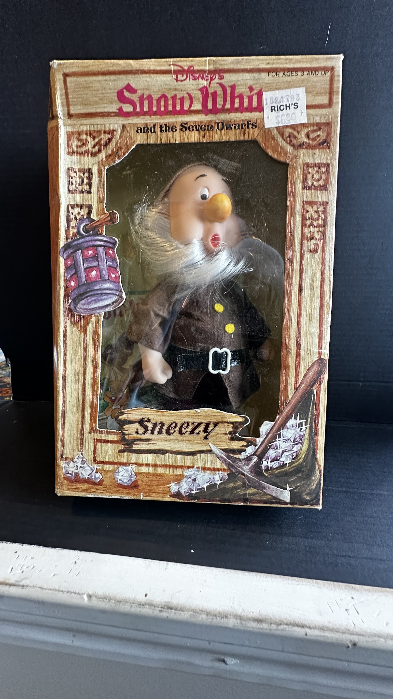 Boxed Sneezy doll from Snow White and the Seven Dwarfs, fabric costume with brown tunic and black belt, vinyl head sculpted mid-sneeze, original window box with mining-themed graphics
