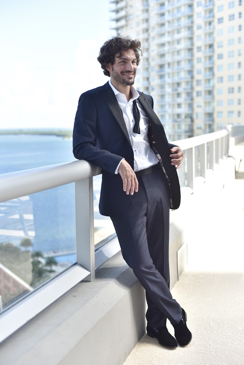 Man in a custom navy tuxedo overlooking waterfront in Miami