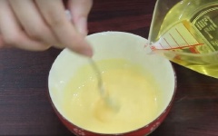 Tiếp theo, nhỏ từ từ 2-3 giọt dầu ăn vào, dùng muỗng khuấy đều theo 1 chiều. Lặp đi lặp lại đến khi hỗn hợp chuyển qua màu vàng nhạt, sệt lại.