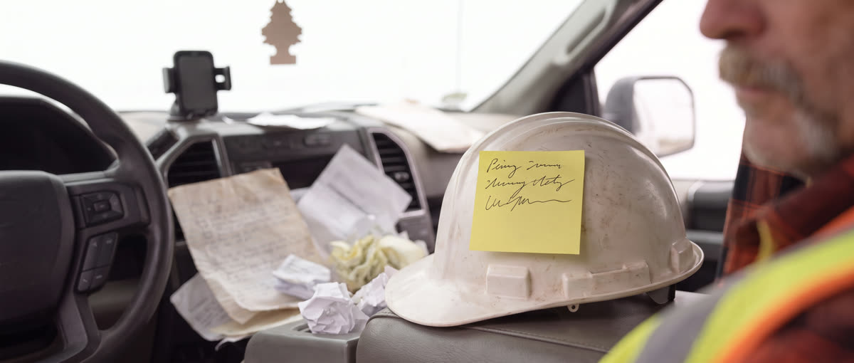 A hard hat with a sticky note stuck to it