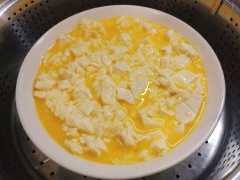Đánh tan 2 quả trứng gà trong thố lớn với 1g muối, 1g tiêu, ít nước lọc, thêm đậu hũ trắng vào dầm cho đậu hũ nát. Cho đậu hũ và trứng vào đĩa, đặt lên xửng hấp khoảng 10 phút là chín.