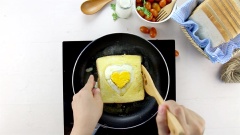 Cuối cùng bạn đặt miếng bánh sandwich còn lại lên rồi nhanh tay lật mặt sandwich để quay phần trứng hình trái tim lên phía trên. Rán thêm 2 phút cho mặt bánh phía dưới vàng giòn thì gắp bánh ra ngoài.