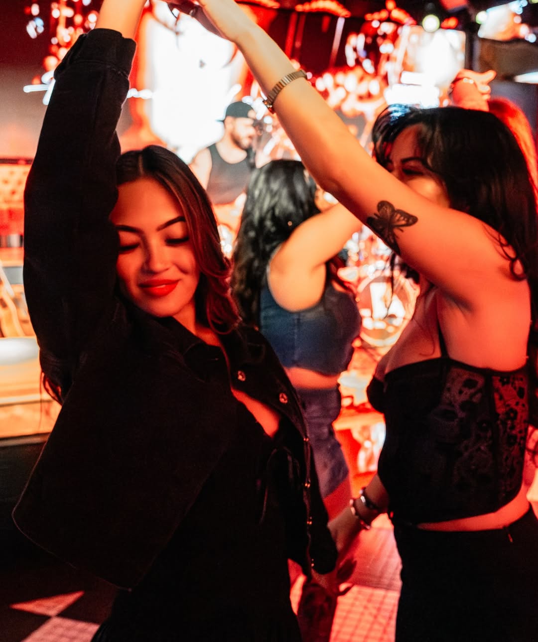 A crowded rooftop scene at Jason Aldean's Kitchen + Rooftop Bar, bustling with lively guests and live performances.