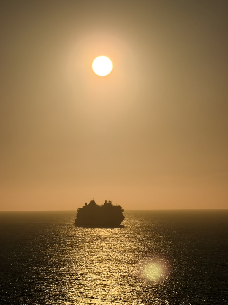 Ferry recortado contra el sol sobre el mar