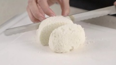 Lột lớp vỏ bên ngoài bánh bao để chúng dễ dàng ngấm trứng đánh. Cắt bánh bao thành những miếng dày. Sau đó mỗi miếng dầy lại cắt đôi nhưng không cắt rời.