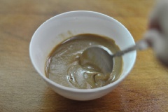 Cho 4 muỗng canh sốt bơ mè vào chén, thêm vào 2 muỗng canh dầu mè khuấy đều.