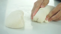 Cắt bột bánh quẩy làm 2, nhồi sơ rồi ấn dẹt, dùng chày cán bột bánh quẩy thành miếng mỏng 1cm.