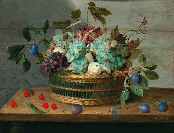 Grapes peaches plums and cherries in a wicker basket with dragonfly and butterfl