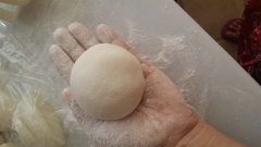 Thoa một ít bột bánh dẻo khô vào 2 tay đẻ chống dính, dùng mu bàn tay ép dẹp tròn miếng bột vỏ bánh dẻo. Sau đó dùng tay nắn miếng bột sao cho phần rìa bột mỏng hơn phần giữa. Đặt viên nhân đậu xanh vào giữa miếng bột bánh dẻo. Dùng tay nhẹ nhàng bao vỏ bột quanh viên nhân. Túm phần mép bột kín lại. Dùng tay vo tròn viên bánh. Rải một ít bột khô lên thớt và dùng tay xoay tròn viên bánh trên thớt, Lớp bột khô bám bên ngoài viên bánh giúp bánh không bị dính vào khuôn.