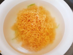 Đun sôi một nồi nước. Cho vào nước 2 muỗng canh dầu ăn và ¼ muỗng cà phê muối để rau muống được xanh và giòn. Cho rau vào, trộn đều rồi vớt ngay ra thau nước đá cho rau được giòn. Sau đó cho mì vào trụng. Mì vừa tơi ra, vừa chín tới thì cũng vớt ra thau nước đá. Sau đó cho mì và rau muống ra rổ cho ráo nước.