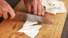Để làm mứt dừa dạng miếng ngon và đẹp mắt, bạn nên chọn cùi dừa không quá già hoặc không quá non. Đem dừa ngâm vào tô nước có pha một ít nước cốt chanh và chút muối, ngâm dừa khoảng 30 phút, sau đó rửa qua 3-4 lần nước đến khi nước trong, nhằm mục đích loại bỏ bớt phần dầu dừa, để thật ráo. Sau đó cho dừa vào nước sôi, chần qua trong khoảng một phút để miếng dừa được tiệt trùng. Mẹo này còn giúp giữ miếng dừa nguyên được màu trắng khi sên mứt.