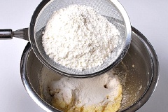 Bột mì chia là 2 phần bằng nhau. Rây vào tô khoai tây nghiền, sau mỗi lần cho bột thì các bạn nhớ trộn đều nhé. Rồi cho lá húng tây khô vào trộn cho hỗn hợp mịn, dẻo.