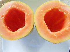 Đu đủ gọt vỏ, cắt làm đôi, dùng muỗng múc bỏ hết hạt. Cắt 1 miếng nhỏ phần đầu hai nửa trái đu đủ để tạo thăng bằng cho đu đủ.