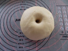 Trong tô lớn, trộn đều 500g bột mì, 1/2 muỗng cà phê muối, 45g bơ, 7g men, 35g đường, 1 lòng đỏ trứng nước và 30ml sữa ấm cho vào nhồi trước, nếu bột hơi khô thì cho thêm nước. Tiếp theo nhồi/trộn cho đến khi bột quyện thành một khối bột dẻo mềm, mịn không dính tay. Cho bột vào âu, phủ khăn ủ 50 phút nơi giữ ấm như: lò nướng mở đèn hoặc nơi gốc bếp.
