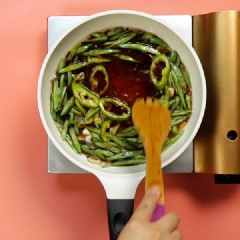 Khi ớt sừng dậy mùi thơm, cho 4 muỗng canh nước tương, 1 muỗng cà phê đường, 1/2 muỗng cà phê muối, 1/4 muỗng cà phê hạt nêm và nửa chén nước vào. Đảo đều tay để đậu que xào được đều vị. Khi thấy nước sốt cạn xăm xắp đậu que thì cho mì tươi vào, đảo đều sạn, rưới nước sốt lên mì để món mì xào đậu que thấm vị đậm đà.